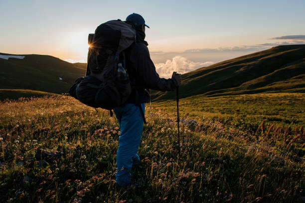 istock One man hiking in the mountains using poles 1240293784