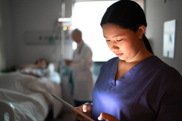 infermiera donna che usa tablet digitale in camera d'ospedale - physicians assistant foto e immagini stock