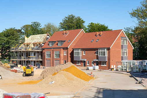 Moulton, Suffolk, England - Feb 19 2015: Traditional detached brick home within landscaped gardens with array of roof mounted photovoltaic solar panels