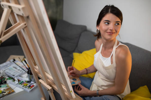 istock A young woman smiling while painting 1240331081