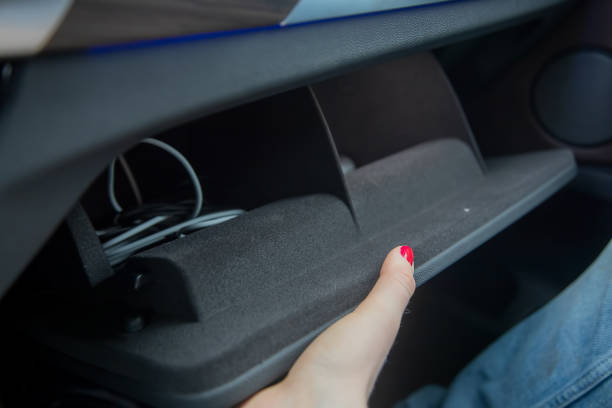 istock female hand opens a glove box in a black car interior. there are cables inside. close-up, soft focus. 1240347227