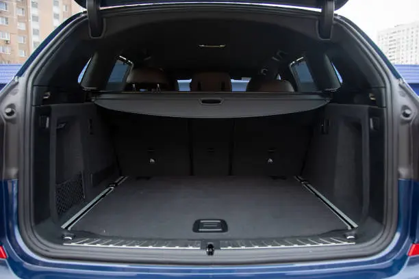 Photo of empty roomy open trunk of modern crossover car, copy space, Rear view of a car with an open trunk, close up, soft focus, blurred background