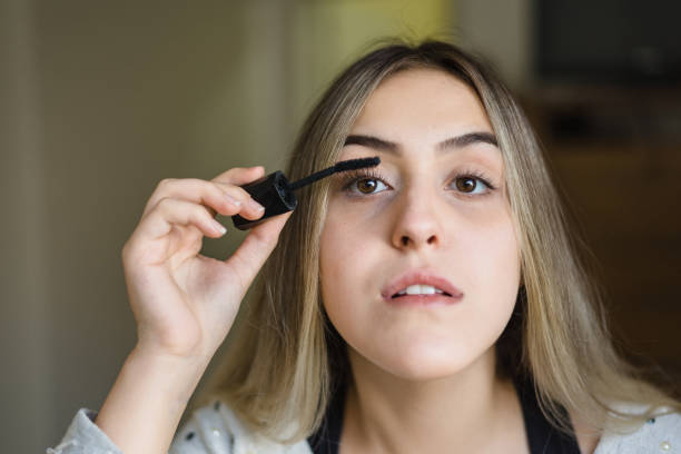 istock Woman in mirror applying mascara on her eyelash 1240350542