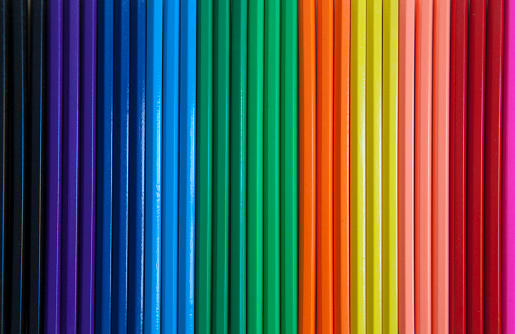 A close up of colored pencils lined up in a row