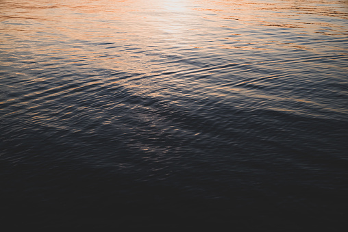 Ripples, waves and interference on calm waters at sunset of Belfast Lough, Northern Ireland.