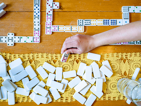 Domino pieces with white background, copy space and various agulos, concept of table games