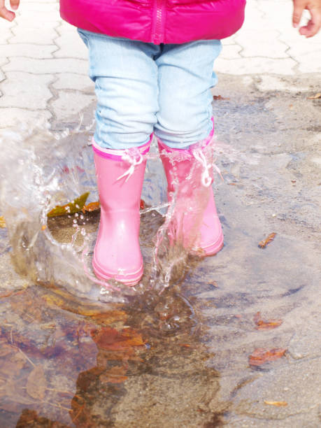 istock Child jumping in the puddles I 1240409985