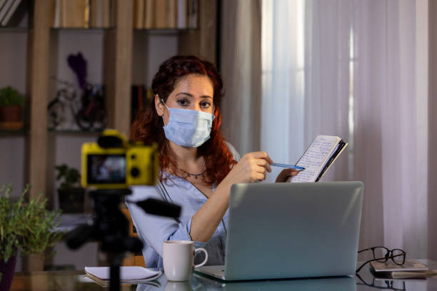 istock Masked woman making live streaming online lesson from home while pandemic days 1240417499