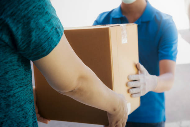istock Young woman receiving parcel from delivery man. 1240420091