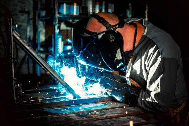 istock Welder in his workshop and blue  sparks 1240450776