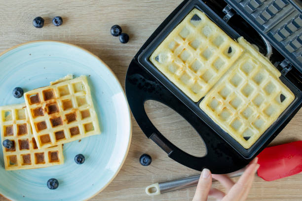 istock Waffles Being Baked in the Waffle Maker. Savory waffles. Breakfast concept 1240451311