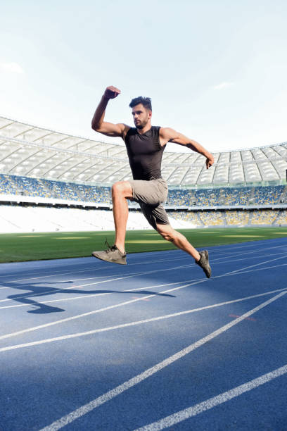 istock handsome runner exercising on running track at stadium 1240469185