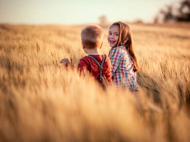 Brother and sister playing in the grain field