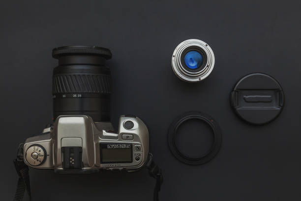 istock Photographer workplace with dslr camera system and lens on dark black table background. Hobby travel photography concept. Flat lay top view copy space 1240487210