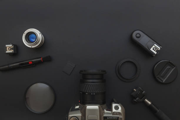 istock Photographer workplace with dslr camera system, camera cleaning kit, lens and camera accessory on dark black table background. Hobby travel photography concept. Flat lay top view copy space 1240487736