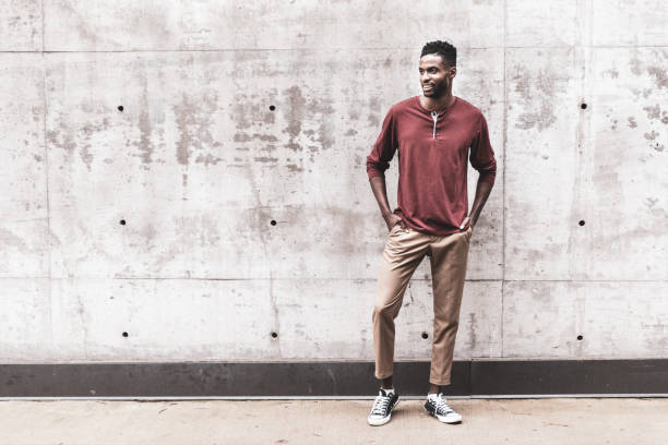 istock Cheerful Black Male Standing by a Concrete Wall 1240498882