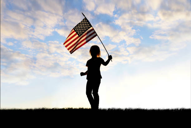 silhueta de criança patriótica acenando bandeira americana - parade flag child patriotism - fotografias e filmes do acervo