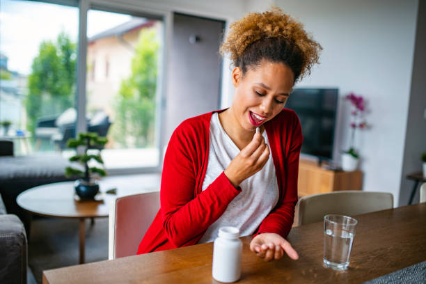 Mixed Race Woman in her late 20s eating nutritional supplements
