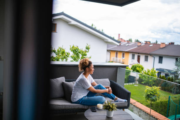 istock Beautiful Mixed Race Woman Sitting on a Couch using Hand Cream 1240575964