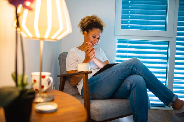 istock Beautiful Mixed Race Woman Reading a book on a digital tablet while using moisturizer 1240575977