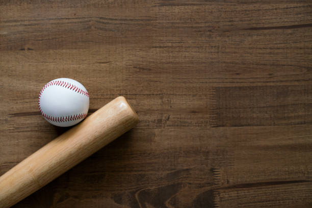 istock baseball and baseball bat on wooden table background, close up 1240580621