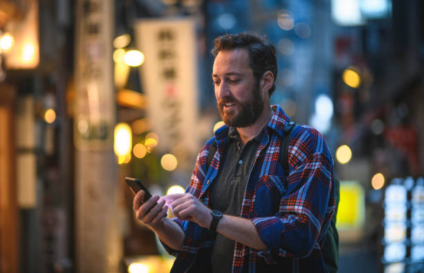 istock Bearded Tourist in Tokyo Checking Smart Phone for Directions 1240647289