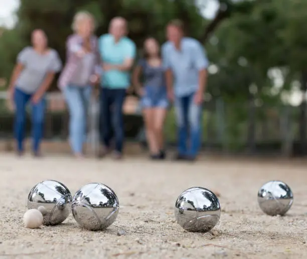 Image of people playing petanque on sand together on holidays