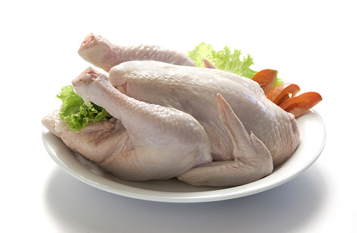 Whole raw chicken, studio shot on white background.