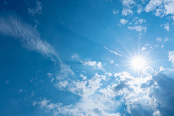 istock blue sky with clouds and sun shines with sunbeams in the day 1240767068