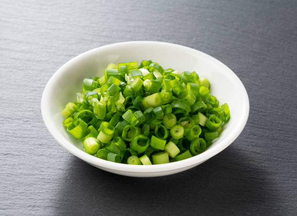 istock Carved green onions placed on a black background 1240917373