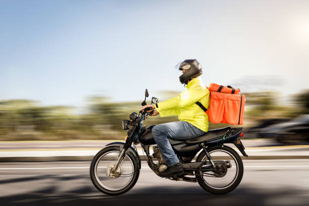 delivery man riding a motorcycle - motoboy - yellow city speed road imagens e fotografias de stock