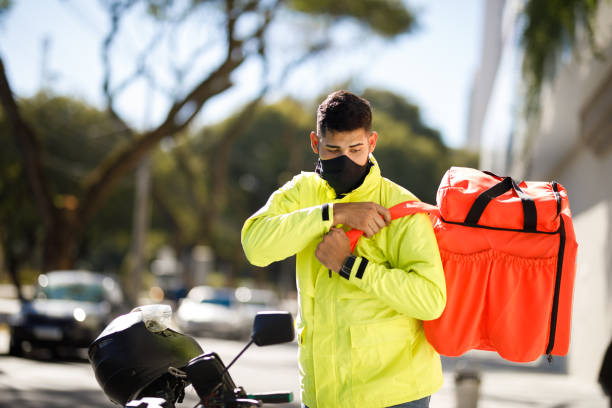 istock Delivery man taking backpack off - motoboy 1240951509