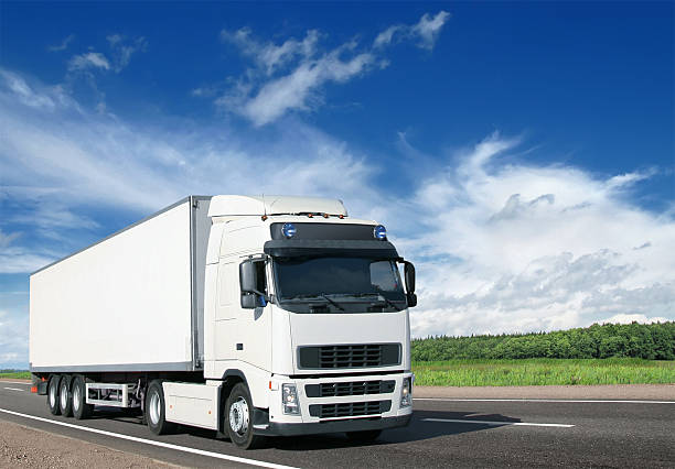 White semi truck and trailer on country highway stock photo