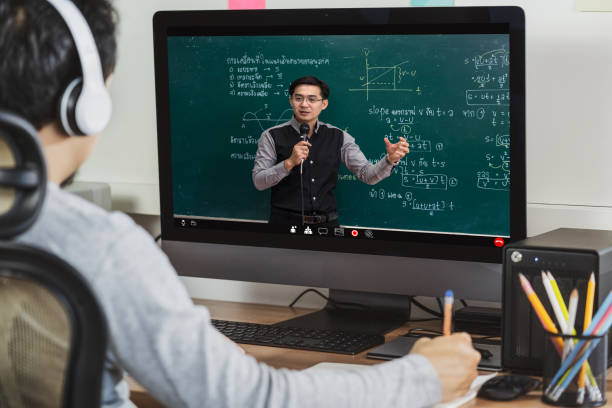 vista trasera del aprendizaje de estudiantes asiáticos con el profesor sobre el formulario de física en laguage tailandés en tablero negro a través de videoconferencia cuando covid-19 pandemia, educación y concepto de distanciamiento social - digital camera fotografías e imágenes de stock