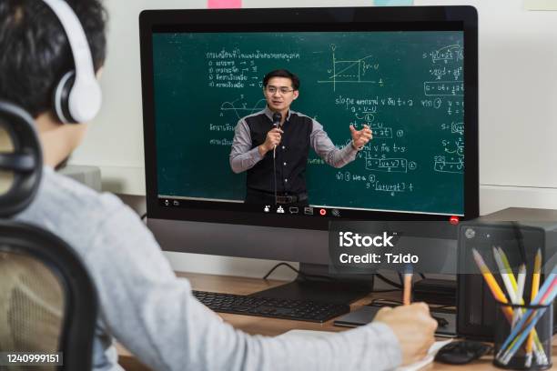 Rear View Of Asian Student Learning With Teacher Over The Physics Formular In Thai Laguage On Black Board Via Video Call Conference When Covid19 Pandemic Education And Social Distancing Concept Stock Photo - Download Image Now