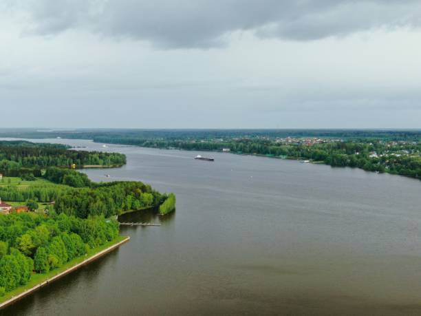 istock Flying over a large cargo ship with open holds sailing down a calm river surrounded by forest. Carriage of goods by river. Beautiful panoramic landscape. Top view down 1241024012