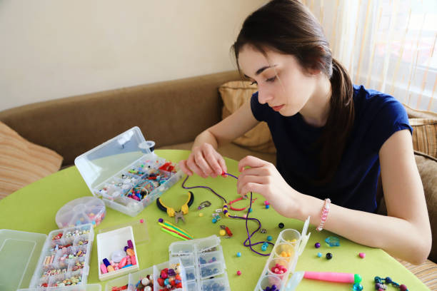 młoda kobieta robiąca bransoletki z koralikami - necklace jewelry bead homemade zdjęcia i obrazy z banku zdjęć