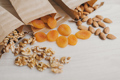 Dried apricot, almond nuts and walnut in eco friendly paper bags. Food storage. Biodegradable package