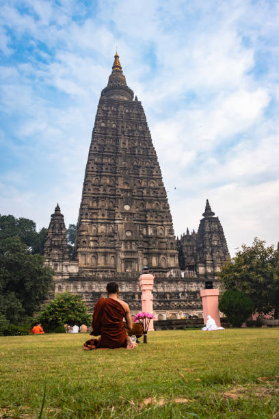 moine bouddhiste méditer isolé le matin avec l’arrière-plan de temple - bodhgaya architecture image human age photos et images de collection