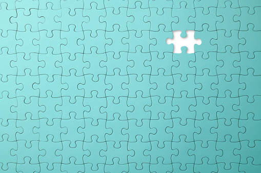 Overhead shot of missing piece of a blank light blue jigsaw puzzle.