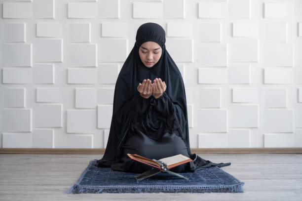 muzułmańska kobieta modlić się z książki koranu - book reading dress women zdjęcia i obrazy z banku zdjęć