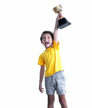Cheerful boy holding a trophy isolated on white background, with clipping path