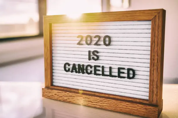 Photo of COVID-19 Coronavirus Quote 2020 IS CANCELLED written on white felt letter board sign. Funny message for public events, outdoor gatherings