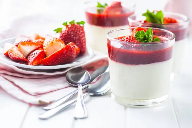 Italian dessert panna cotta in glass with strawberries.