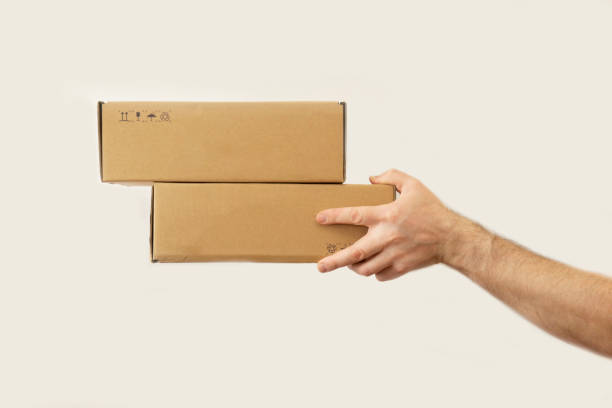istock man's hand gives two boxes. dark white background. delivery concept. 1241094930