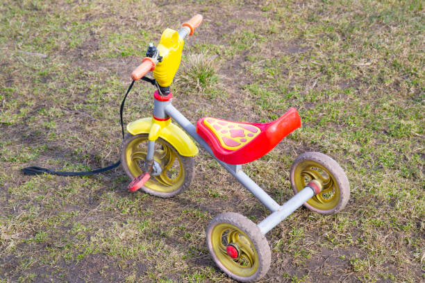 istock old three-wheeled bicycle for children stands on the grass 1241095180