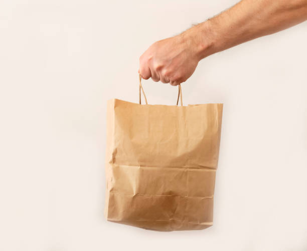 istock man gives a paper bag White background. 1241095262