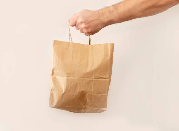 istock man gives a paper bag White background. 1241095276