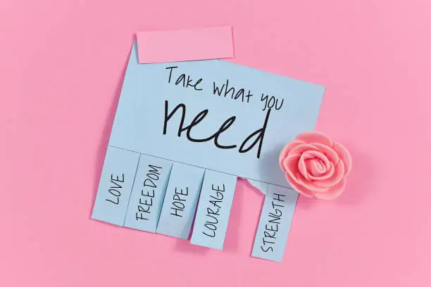 Blue tear-off stub note with handlettering text 'Take what you need' and words 'Love, Freedom, Hope, Courage' and 'Strength' on pink background with cute pink foam rose