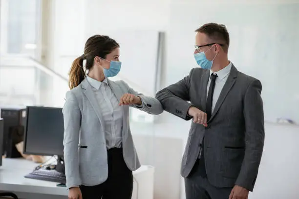 Photo of Businessman and businesswoman with medical mask in office.